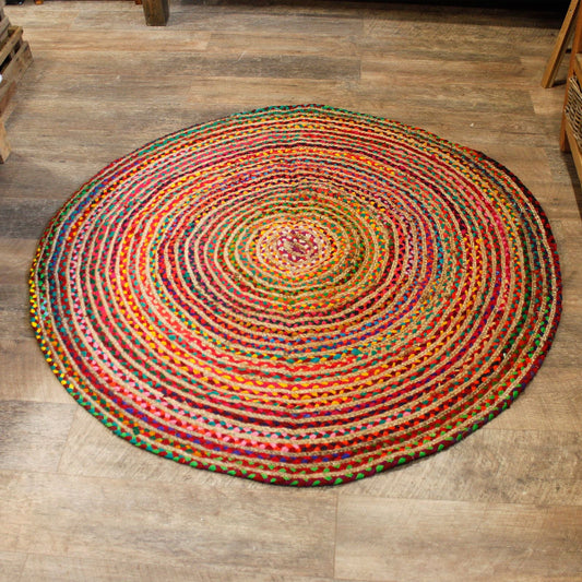 Round multicolored braided rug on a wooden floor