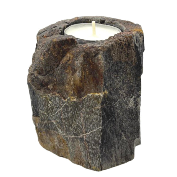 Candle holder made of stone with a lit candle inside on a white background