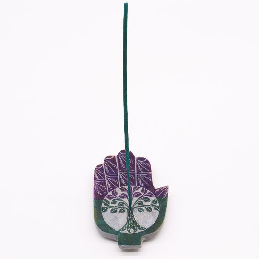 Decorative incense holder shaped like a hand with tree of life design on a white background
