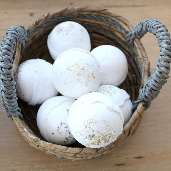 Basket filled with white bath bombs on a wooden surface