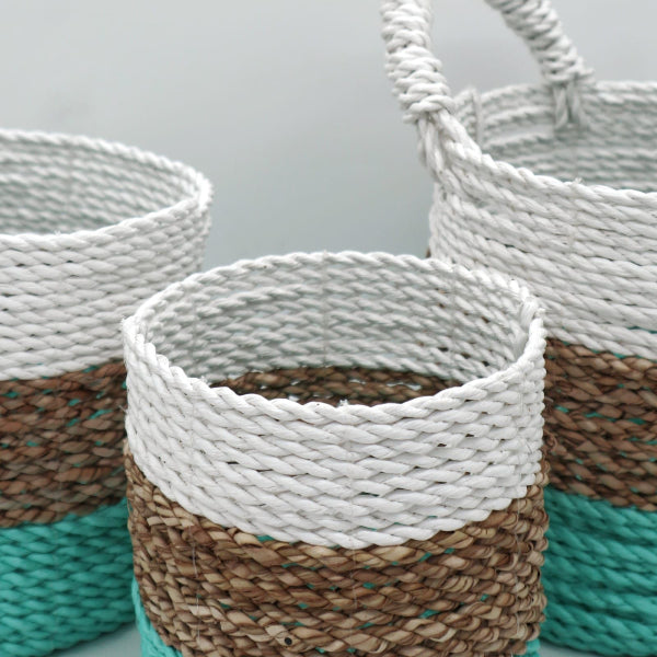 Set of woven baskets with a mix of white, brown, and turquoise colors on a light gray background.