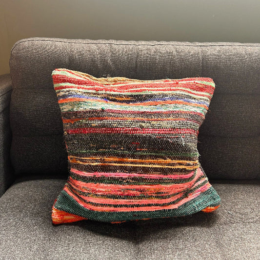 Multicolored striped pillow on a gray sofa