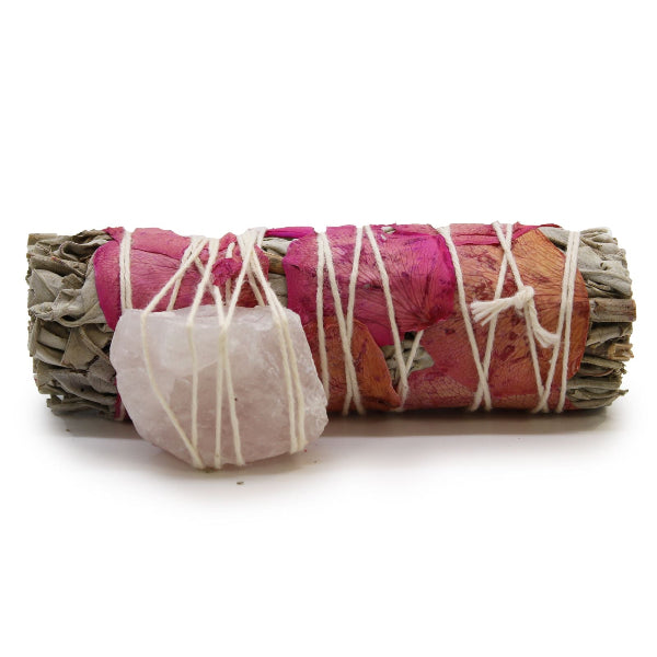 Sage bundle wrapped with pink fabric and white string on a white background