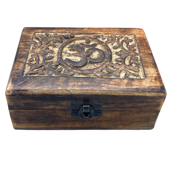 Wooden box with Om symbol and floral carvings on a white background