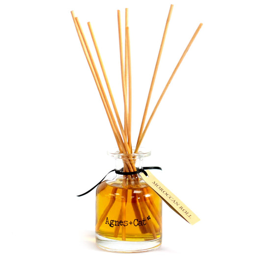 Aromatherapy diffuser with wooden sticks and a label on a white background