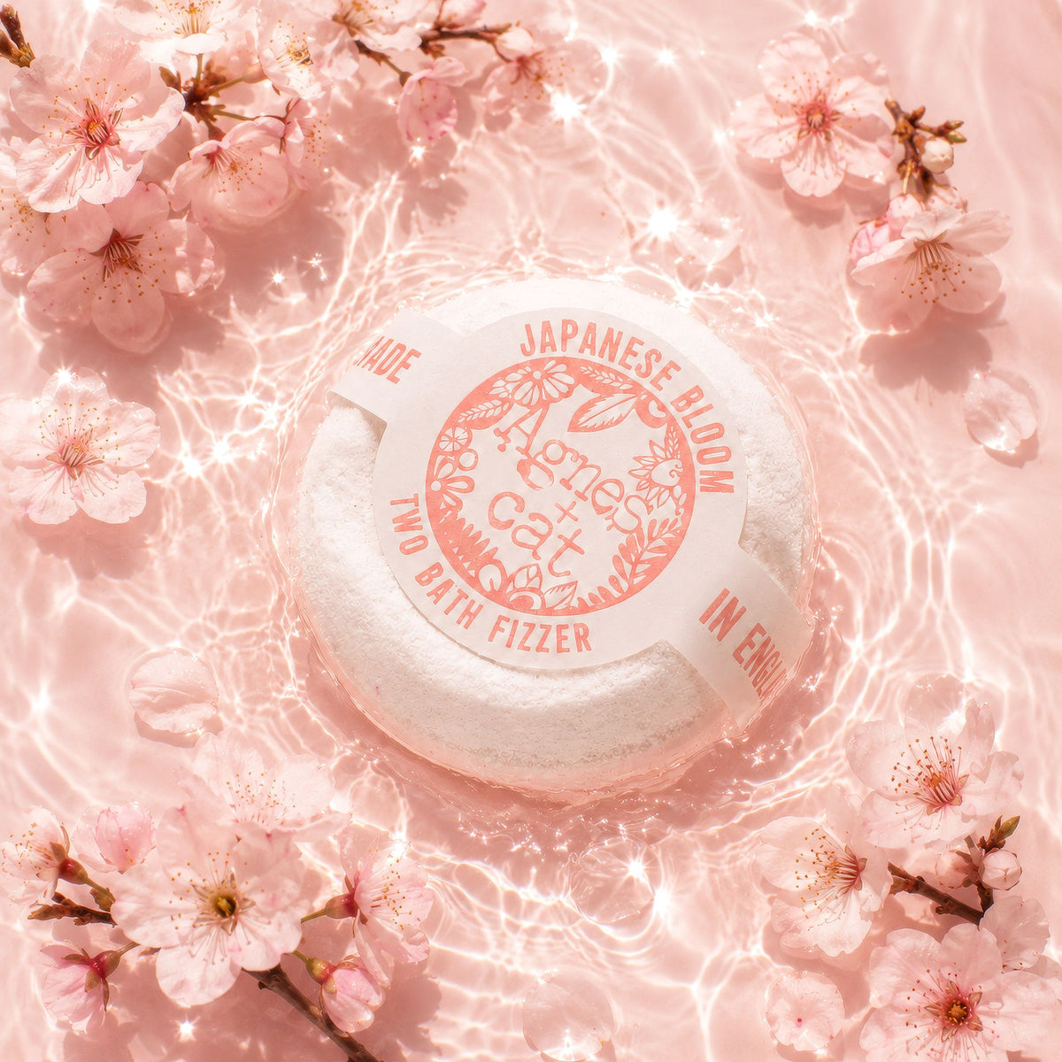 Bath fizzer with cherry blossoms on a pink background
