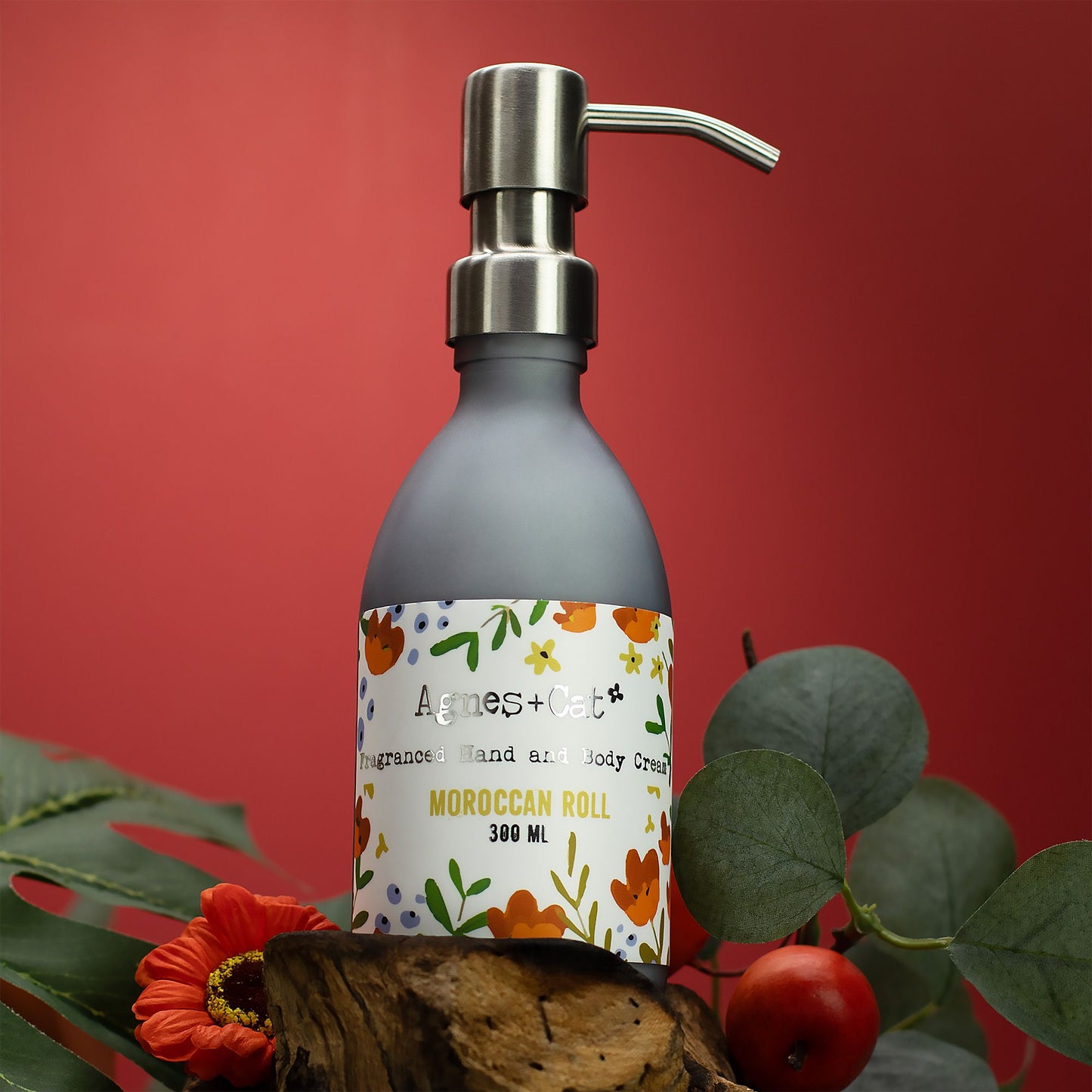 Soap dispenser with floral label on a red background