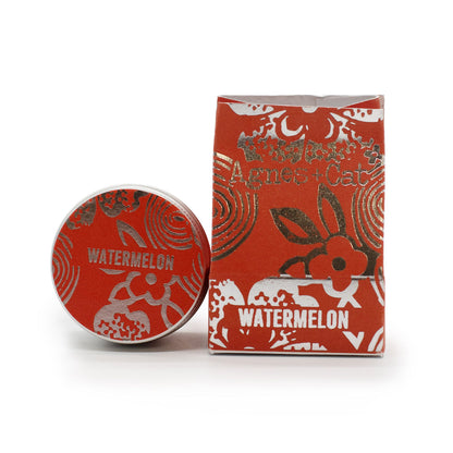 Red and white cosmetic container with 'Agnes + Cat' branding on a white background