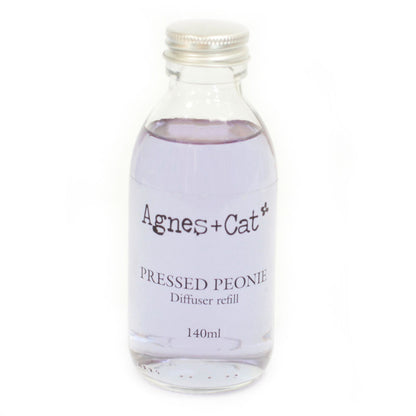 Glass diffuser refill bottle labeled 'Agnes + Cat Pressed Peony' on a white background
