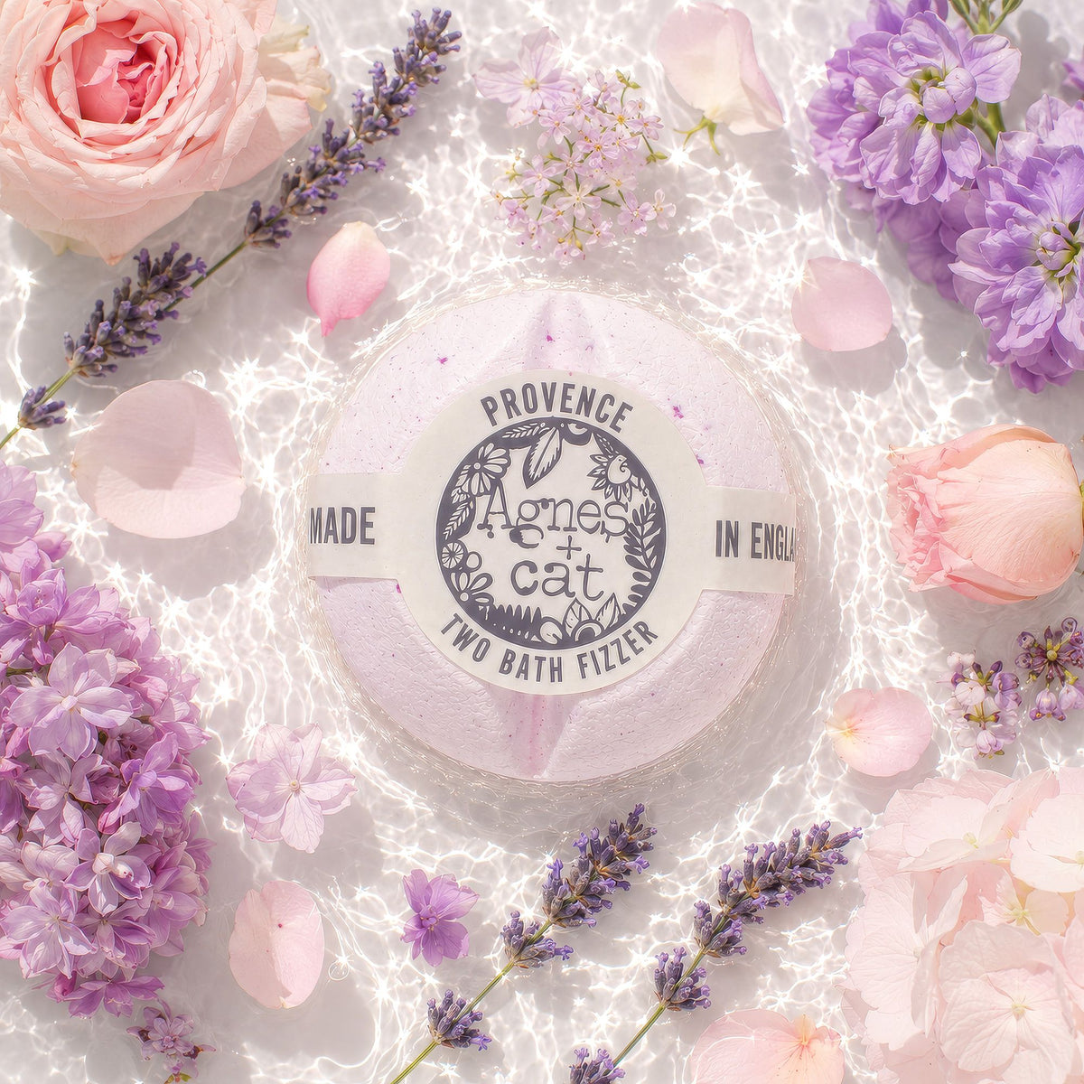 Bath fizzer with 'Agnes & Cat' branding surrounded by flowers on a light background