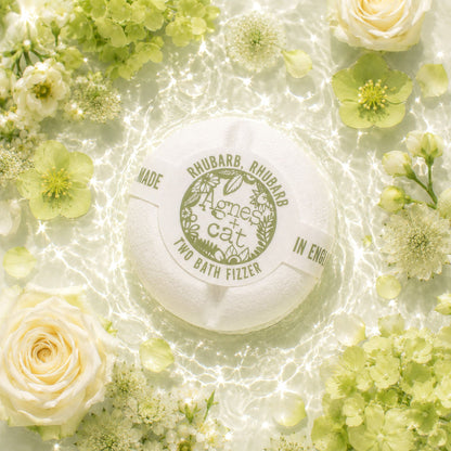 Bath fizzer surrounded by green and white flowers on a light background