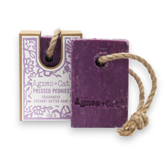 Purple soap bar with rope and packaging labeled 'Agnes + Cat' on a white background