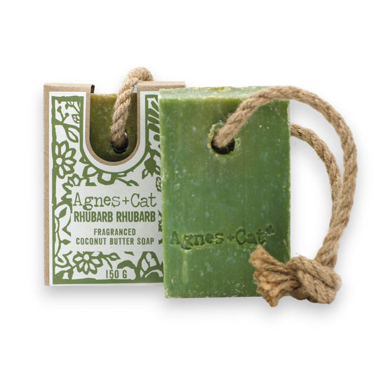 Green soap bar with a rope and packaging labeled 'Agnes + Cat' on a white background