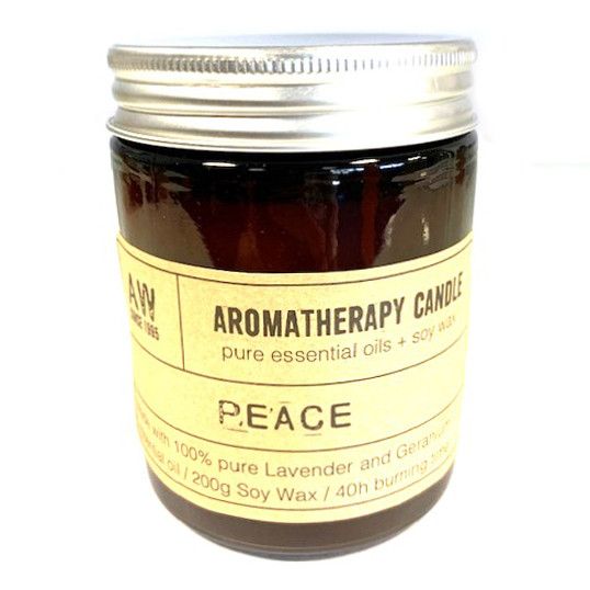 Aromatherapy candle labeled 'Peace' with a metal lid on a white background