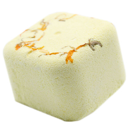 Square bath bomb with orange and brown specks on a white background