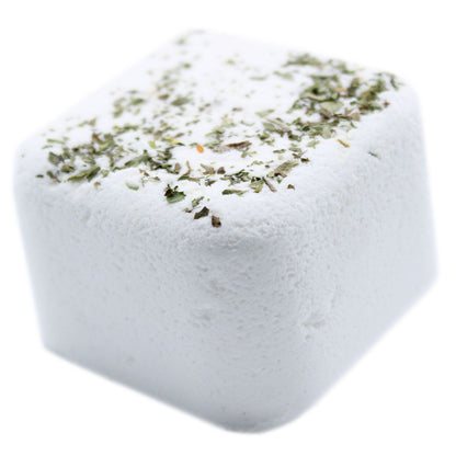 Square block of white salt with green herbs on a white background