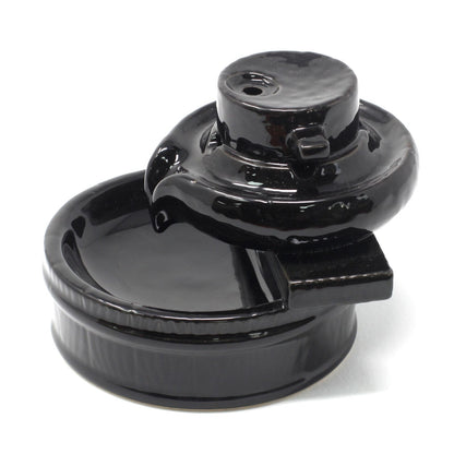 Black ceramic backflow burner on a white background