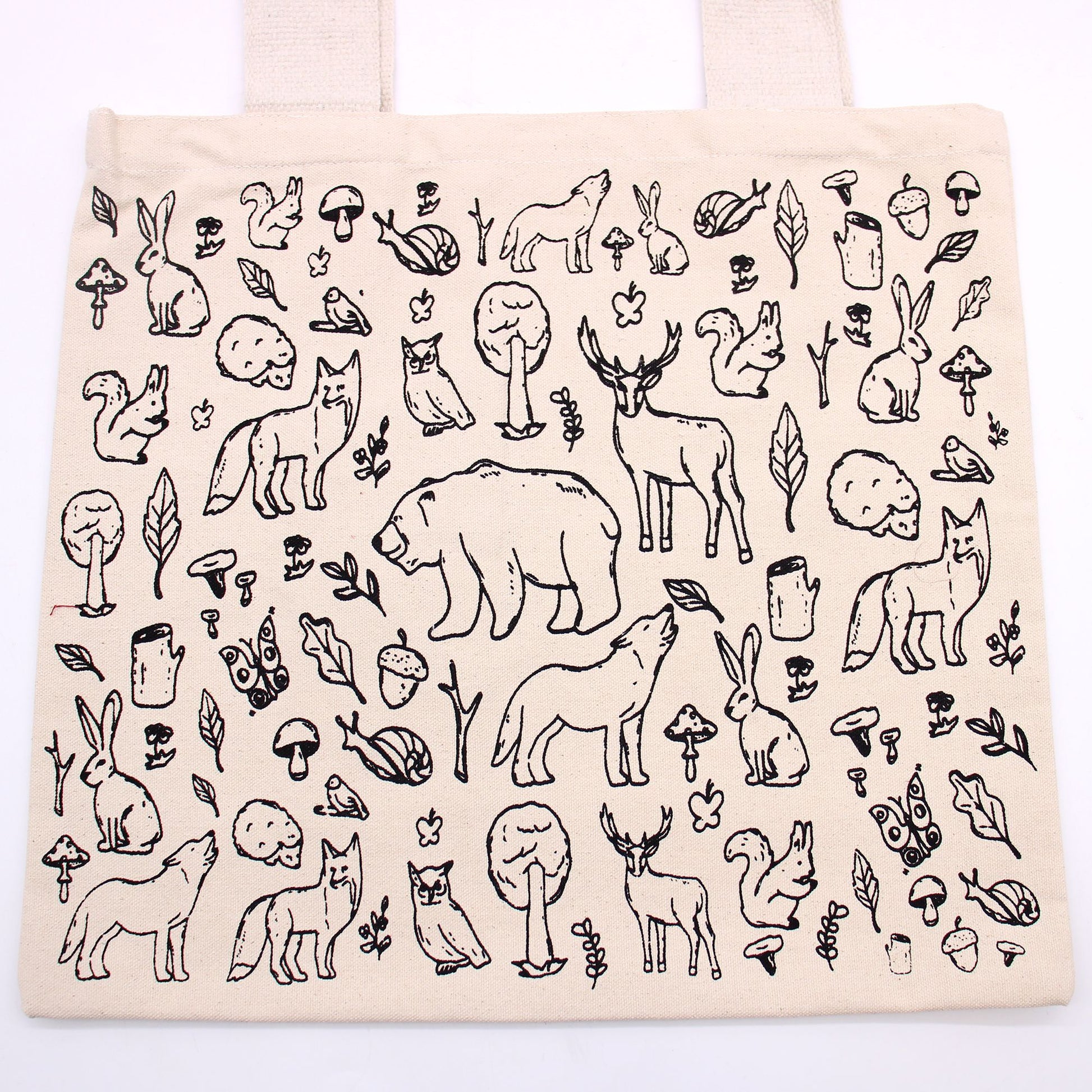 Beige tote bag with black line art of animals and nature on a white background