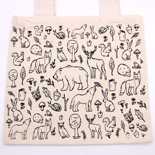 Beige tote bag with black line art of animals and nature on a white background