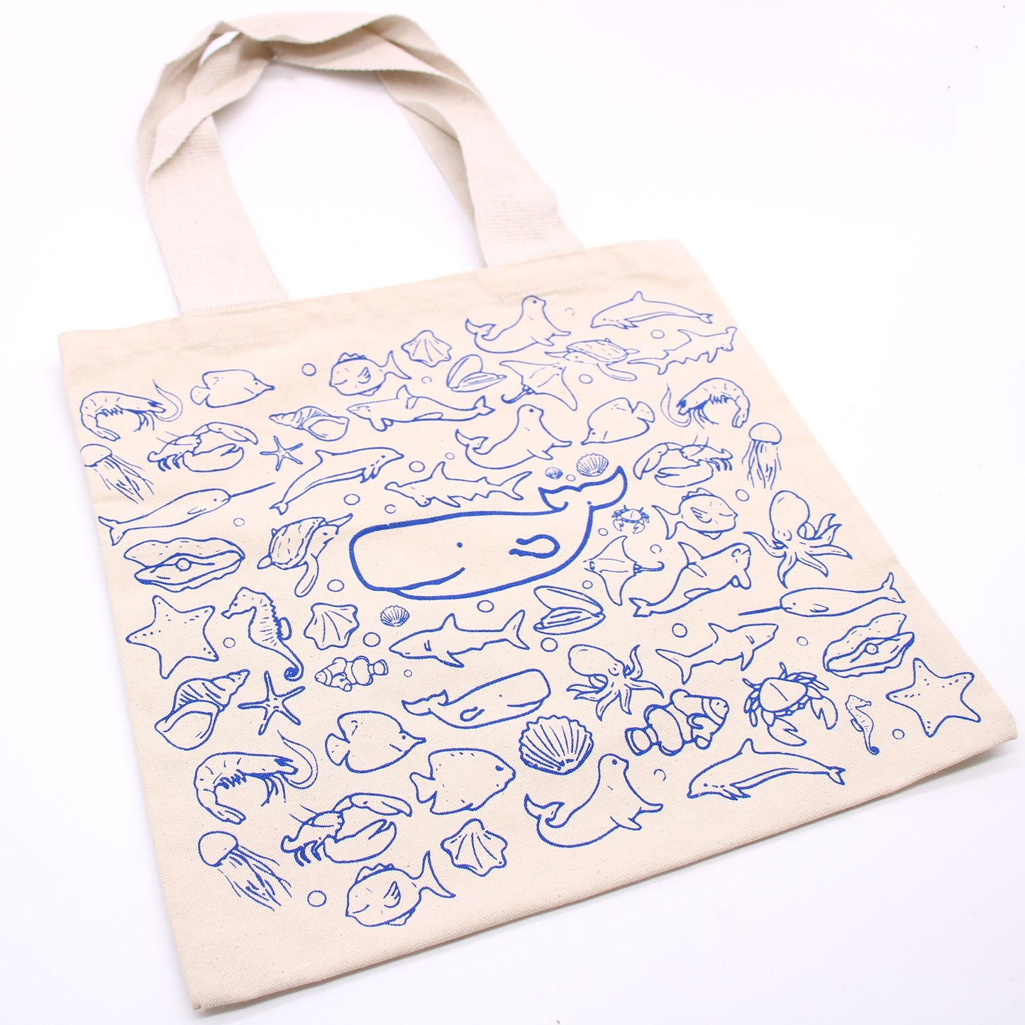 Beige tote bag with blue sea creature patterns on a white background