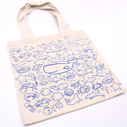 Beige tote bag with blue sea creature patterns on a white background