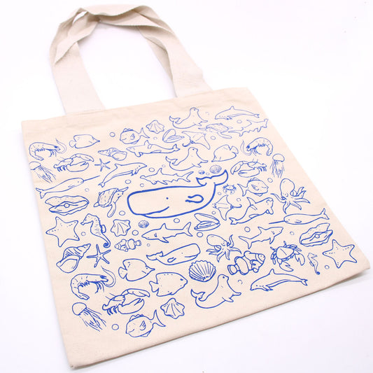 Beige tote bag with blue sea creature patterns on a white background