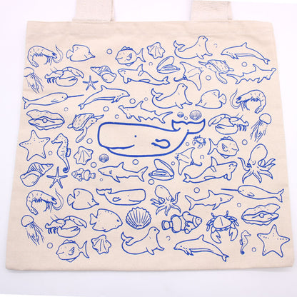 Tote bag with blue ocean-themed illustrations on a white background