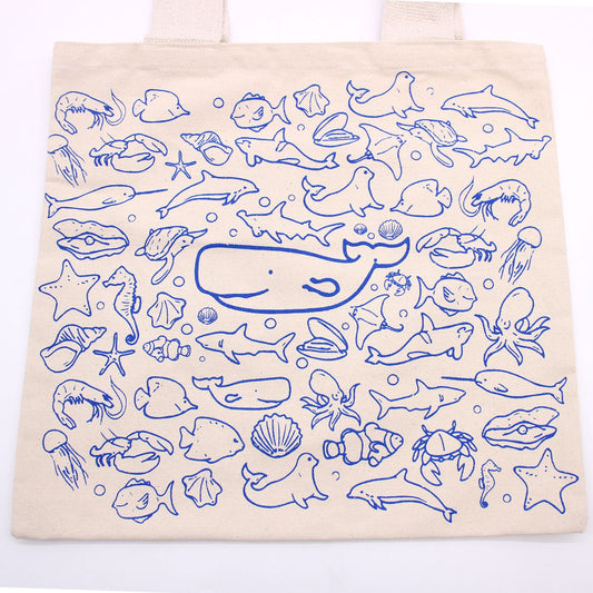 Tote bag with blue ocean-themed illustrations on a white background