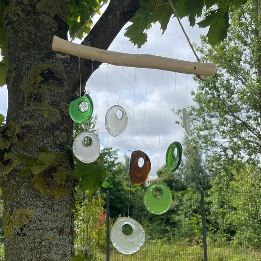 Bring harmony and a touch of nature to your outdoor space with a Recycled Glass Wind Chime Bottle Bottoms Chime - Assorted. Handmade in Indonesia
