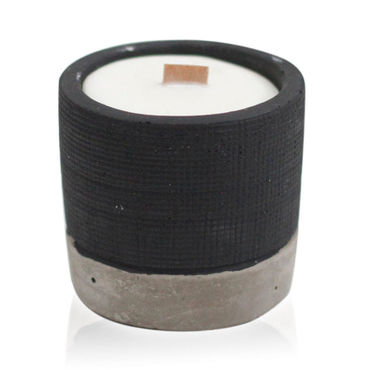 Cylindrical candle with black textured band and concrete base on a white background