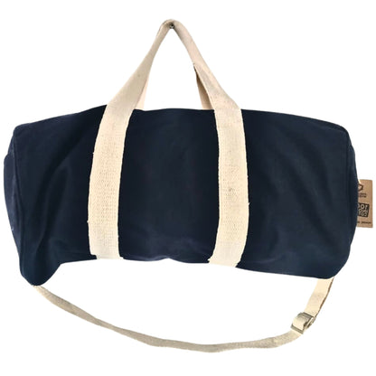 Navy blue duffel bag with beige handles and strap on a white background