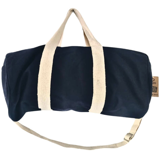 Navy blue duffel bag with beige handles and strap on a white background