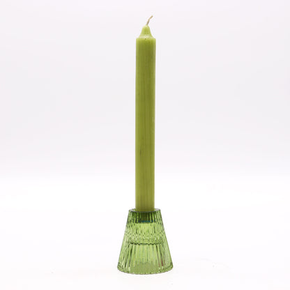 Green candle in a decorative holder on a white background