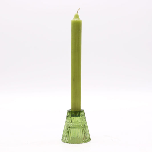 Green candle in a decorative holder on a white background
