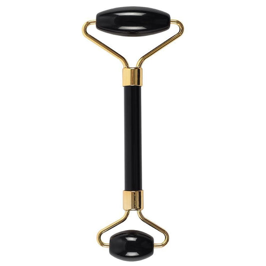 Black and gold facial roller on a white background