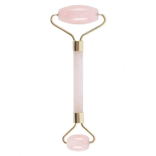 Pink and gold facial roller on a white background