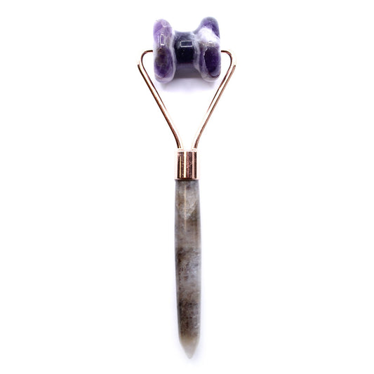Gua Sha tool with purple stone roller on a white background