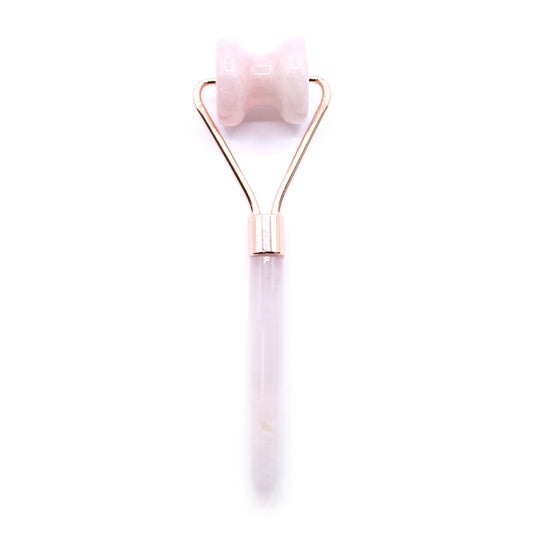 Rose gold and white facial roller on a white background