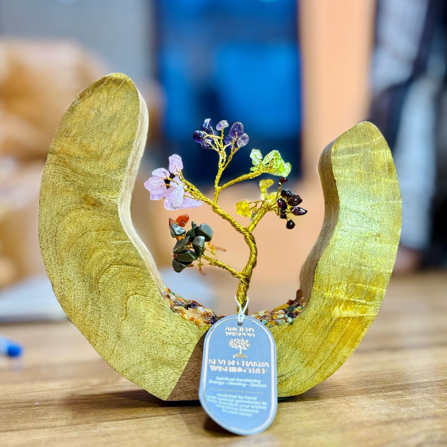 Decorative item with a tree sculpture inside a wooden boat on a table.