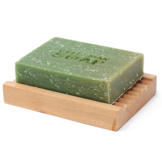 Green bar of soap on a wooden soap dish with 'Green Soap' branding.