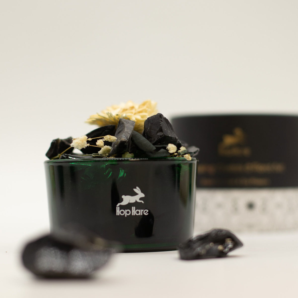Black container with decorative elements and a visible brand logo on a light background