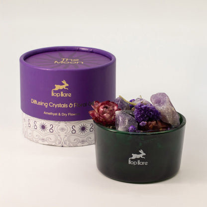 Diffusing crystals and floral mix in a black container with a purple lid, featuring the 'lop itare' brand.