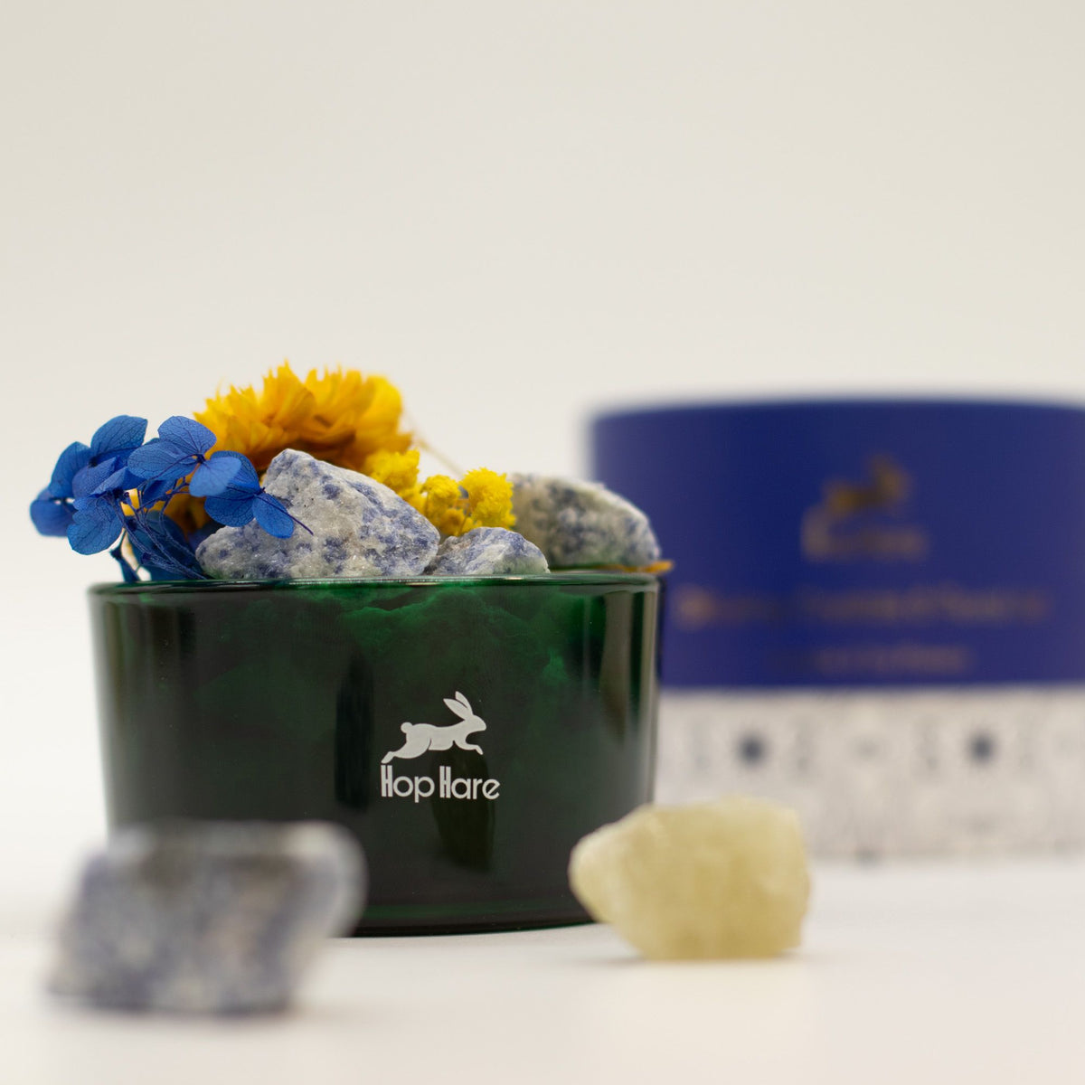 Green container with rocks and flowers, featuring the 'lloplare' brand logo.