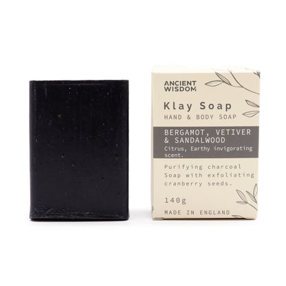 Black bar of soap with its packaging on a white background