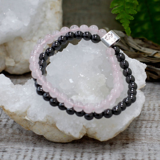 Black beaded bracelet with a silver clasp on a crystal surface