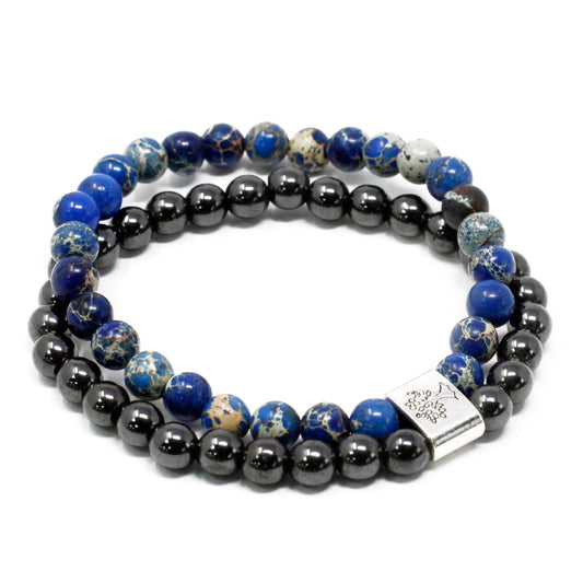 Stack of beaded bracelets with blue and black stones on a white background