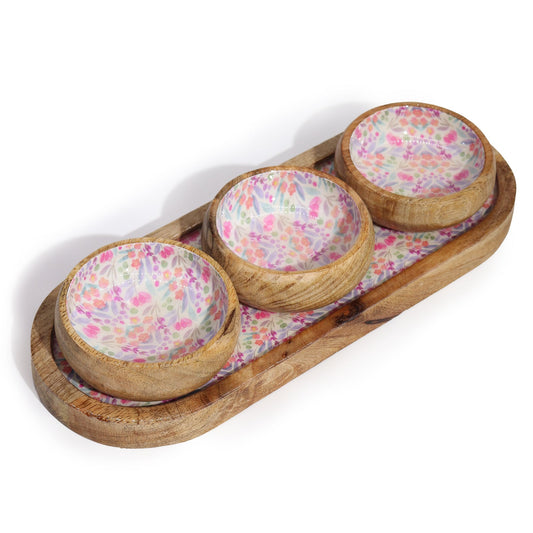 Wooden tray with three floral-patterned bowls on a white background