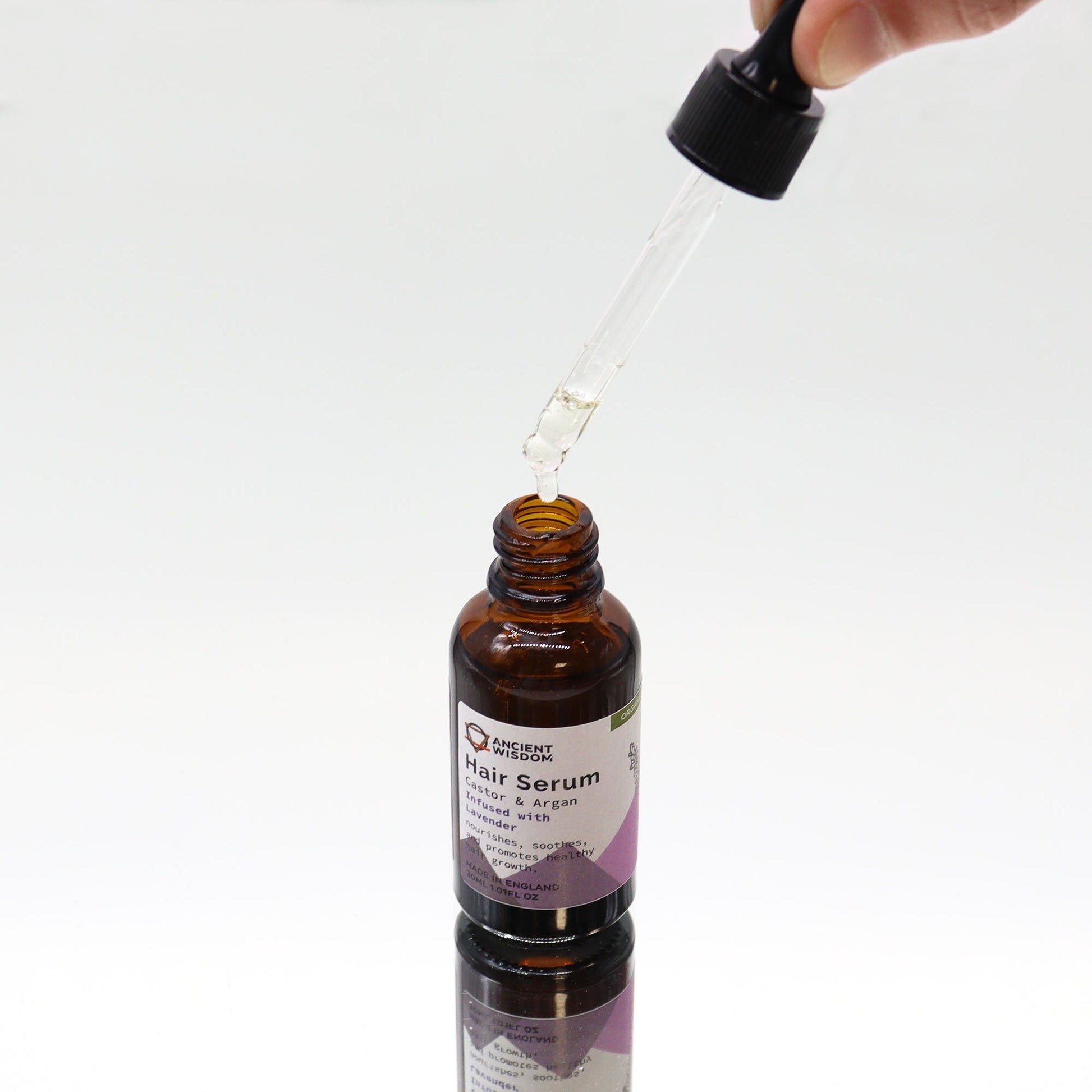 Hair serum bottle with dropper on a white background