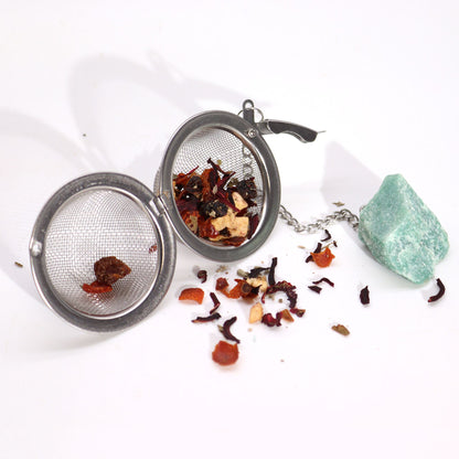 Tea ball with loose tea leaves on a white background