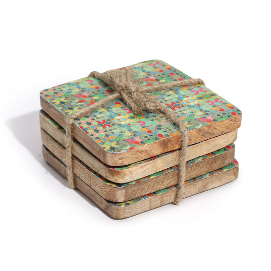Set of four wooden coasters with colorful pattern tied together with twine on a white background